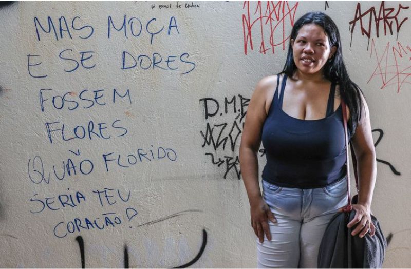 Brasília - A babá Carolina Sales, ao lado de versos pichados em muro da capital - Foto Valter Campanato/ Agência Brasil